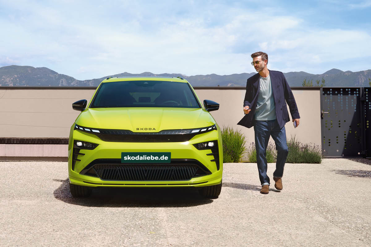 Mann geht neben E Auto